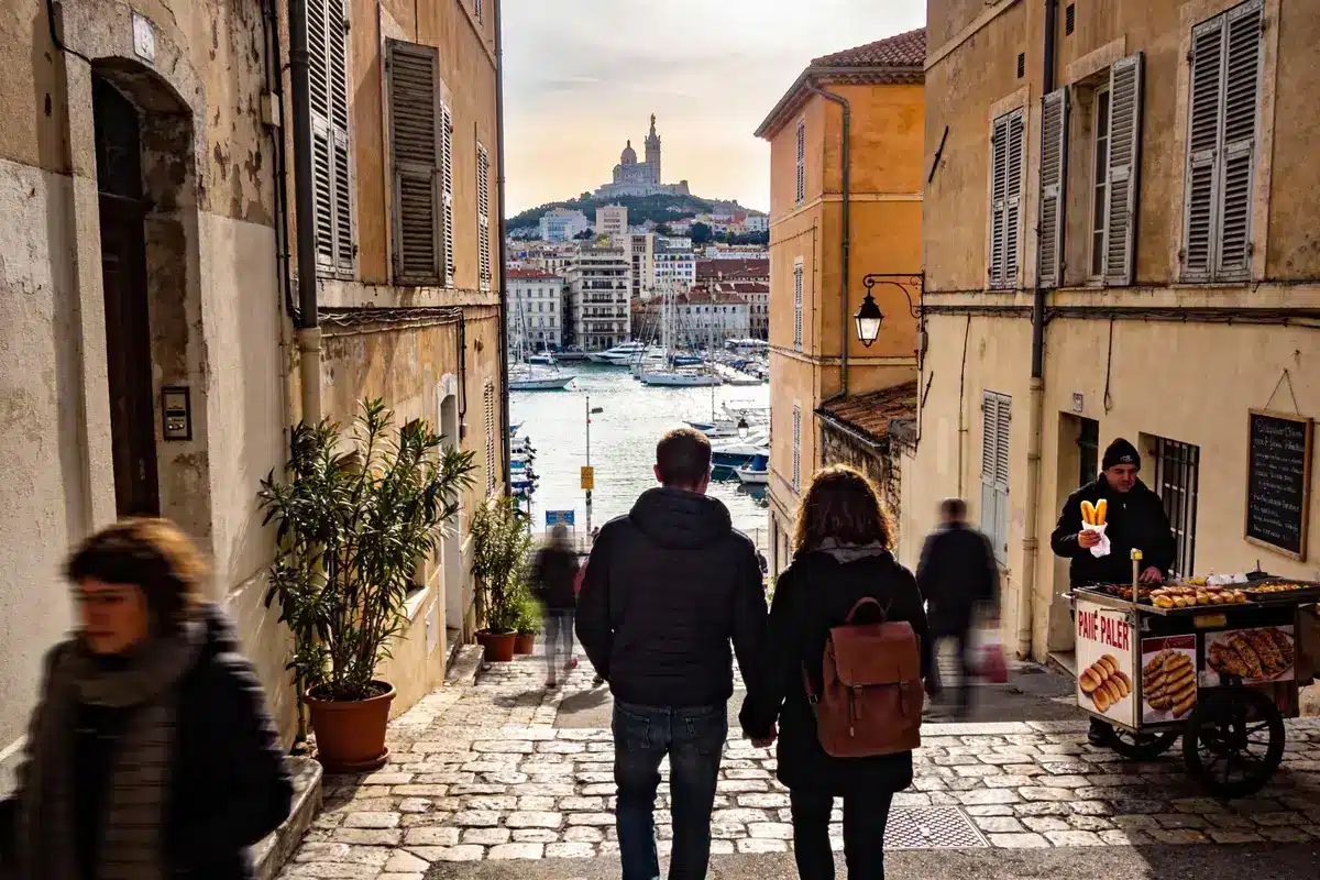 Promeneurs sur le quai du Vieux-Port de Marseille, basilique Notre-Dame de la Garde en arrière-plan.